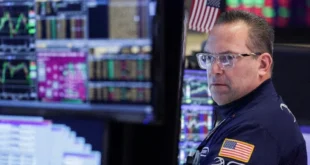 Operador en la Bolsa de Nueva York analizando gráficas alcistas tras noticias de tregua