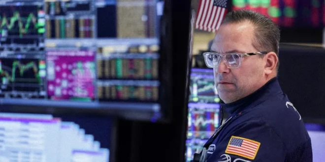 Operador en la Bolsa de Nueva York analizando gráficas alcistas tras noticias de tregua