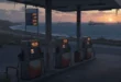 Estación de servicio con precios de gasolina elevados y barcos petroleros en el horizonte