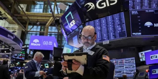 Pantallas de cotizaciones bursátiles de Wall Street en verde y mapa del estrecho de Ormuz