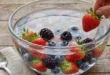 Tazón de fresas y arándanos sumergidos en agua con bicarbonato para eliminar residuos de pesticidas de su superficie