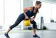 Mujer en ropa deportiva realizando entrenamiento de fuerza con una pesa rusa en un gimnasio iluminado
