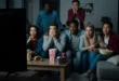 Grupo de amigos asustados viendo una película de terror en una sala oscura