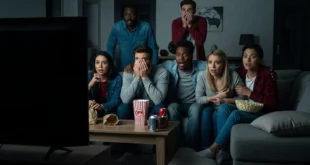 Grupo de amigos asustados viendo una película de terror en una sala oscura
