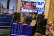 Operadores de Wall Street analizando pantallas financieras tras la caída del mercado por tensiones geopolíticas.