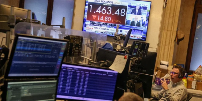 Operadores de Wall Street analizando pantallas financieras tras la caída del mercado por tensiones geopolíticas.