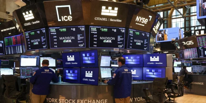 Operadores financieros analizan pantallas de cotizaciones en el parqué de Wall Street