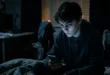 Persona joven mirando su smartphone en un entorno oscuro, reflejando el impacto en la salud mental.