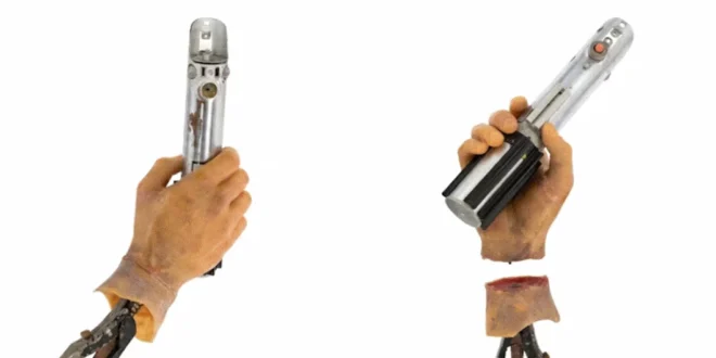 Réplica detallada del sable de luz de Luke Skywalker y su mano robótica sobre fondo blanco.