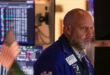 Operador en la Bolsa de Nueva York observando el nuevo récord del índice Dow Jones