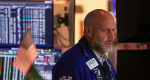 Operador en la Bolsa de Nueva York observando el nuevo récord del índice Dow Jones