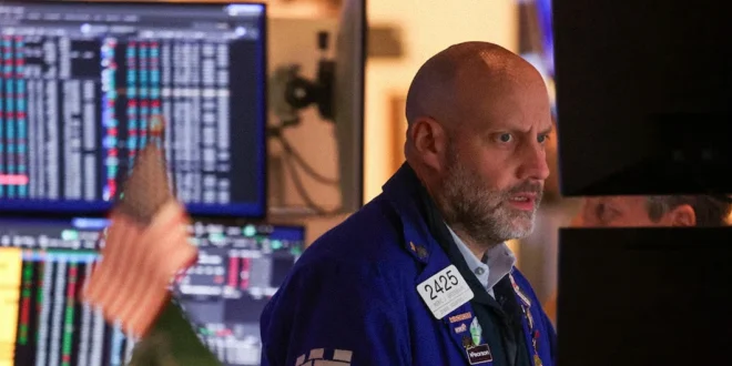Operador en la Bolsa de Nueva York observando el nuevo récord del índice Dow Jones