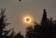 La corona solar brillando intensamente detrás de la silueta negra de la Luna durante el eclipse total
