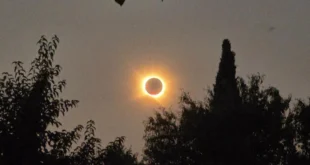 La corona solar brillando intensamente detrás de la silueta negra de la Luna durante el eclipse total