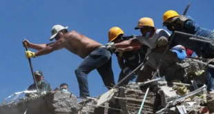 Equipos de rescate y voluntarios trabajando entre los escombros de un edificio colapsado en Cali, Colombia.