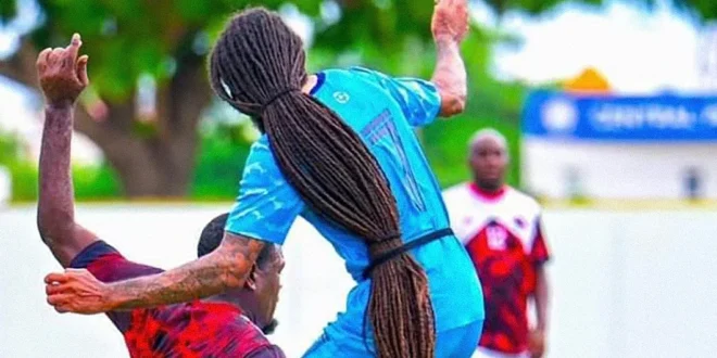 Aedan Scipio, futbolista de Anguila con rastas largas, disputando un balón en un partido oficial.